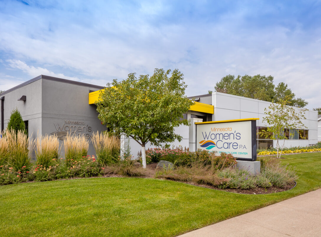 Exterior of the Minnesota Women's Care clinic showing the site abundantly landscaped with native Minnesota plants.