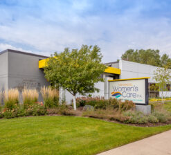 Exterior of the Minnesota Women's Care clinic showing the site abundantly landscaped with native Minnesota plants.