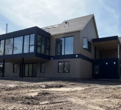 A rear exterior view of the Sirkel Kjøre residence during construction. At this stage of construction, there is no landscaping surrounding the house.