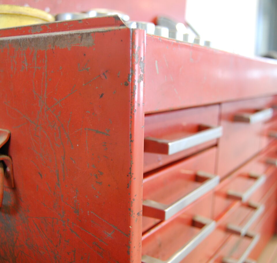 A red metal tool cabinet used to describe the portion of the design process where a general contractor is selected for the project.