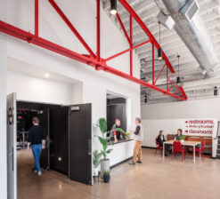 A person walking into the primary theater entrance and someone taking a person's order at the adjacent concession stand at the former HUGE Improv Theater.