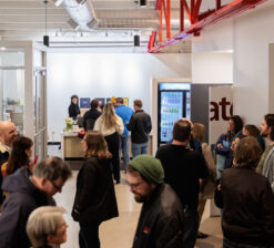 Audience members standing and waiting in the lobby of the HUGE Improv Theater during a live performance intermission.