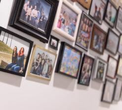 A wall of framed photographs of groups that performed at the HUGE Improv Theater over the last few decades.